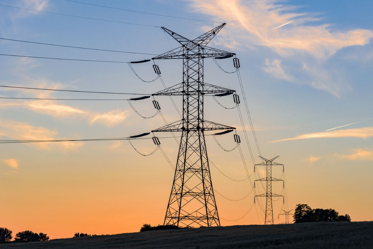 transmission towers and power lines at sunset